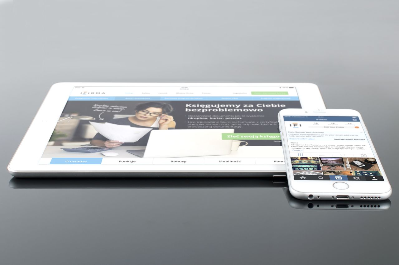 Tablette et smartphone modernes affichant du contenu web sur une surface réfléchissante, mettant en avant la technologie et la connectivité.
